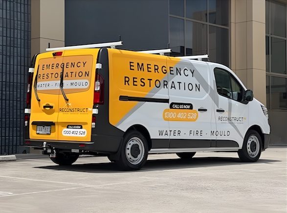 Reconstruct TM emergency restoration van parked outside a building, ready for 24/7 service.